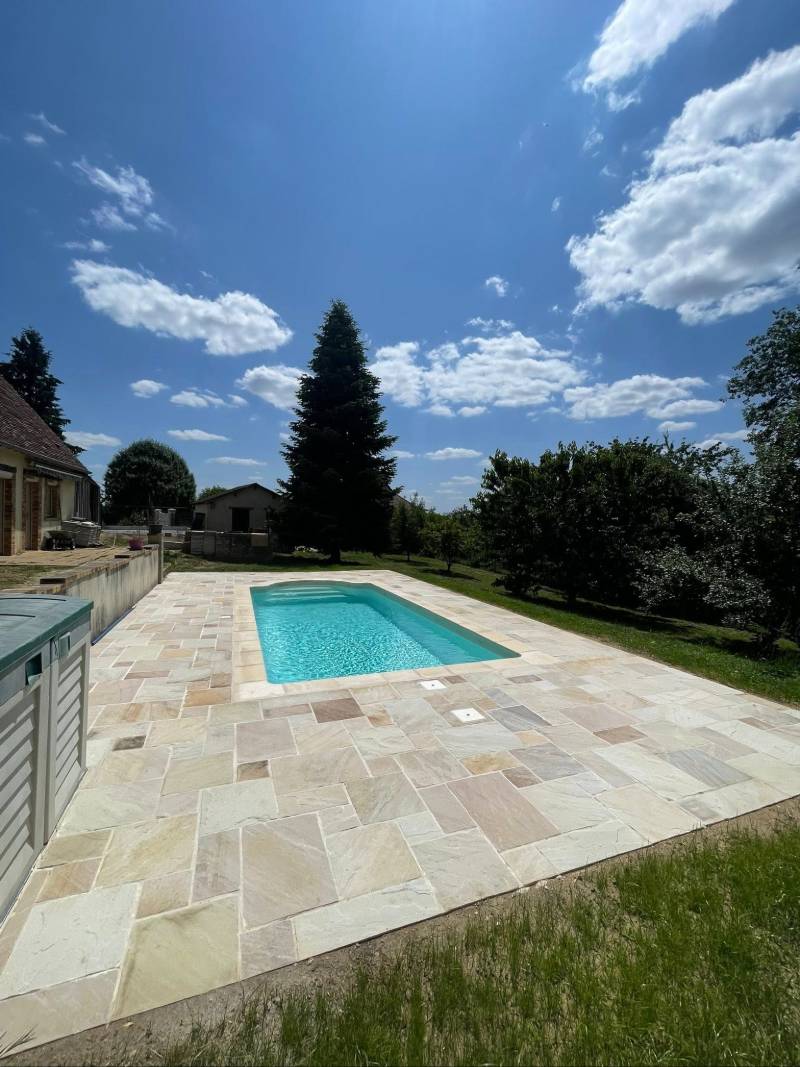 Aménagement piscine extérieure en pierres blanche